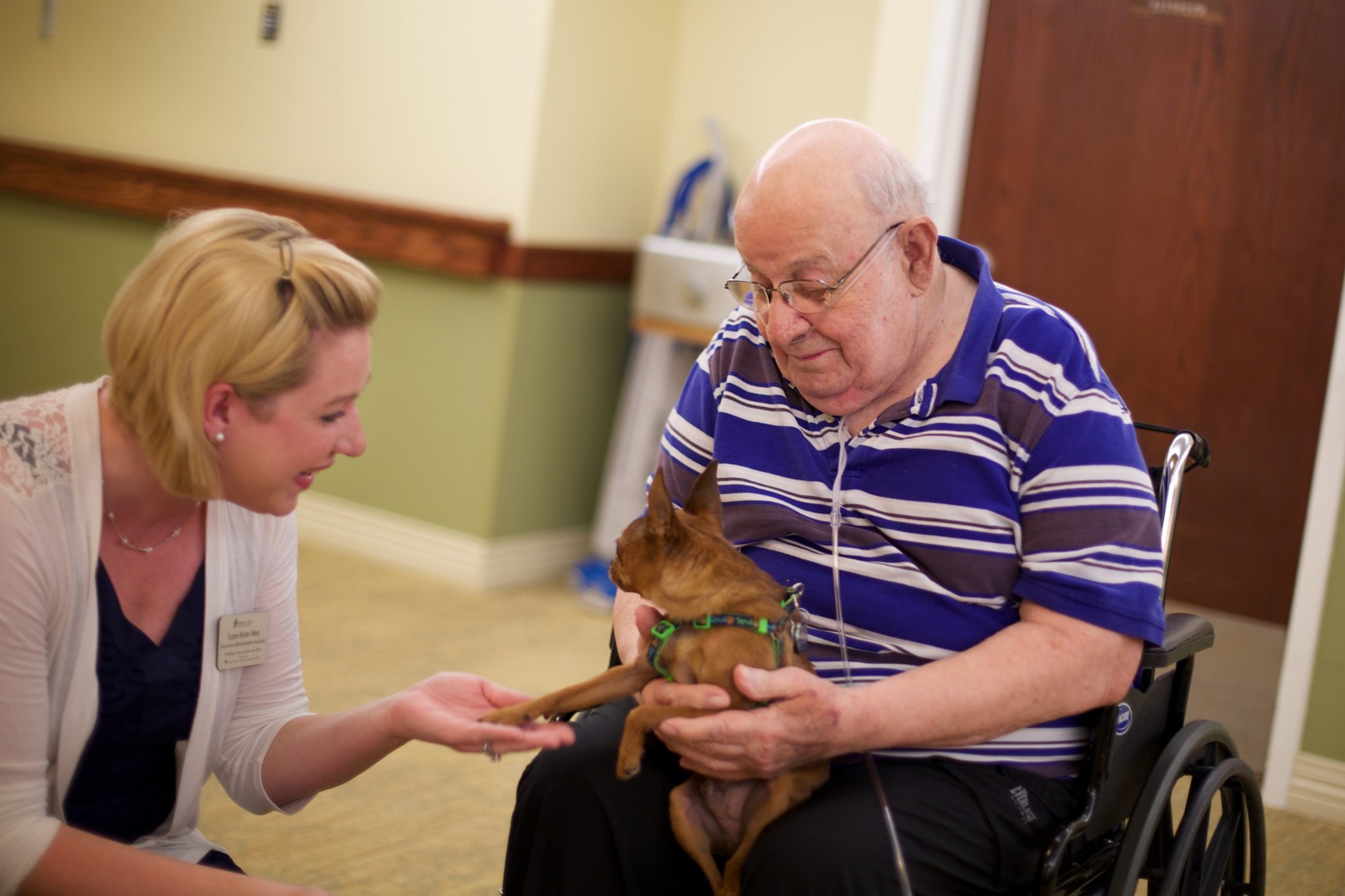 Someren Glen Senior Living Community in Centennial, CO - team member talking to resident and his dog largelandscape